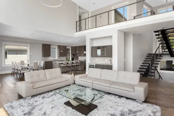 Spacious modern living room with a kitchen and dining area, captured with a real estate photography lens to showcase its open-concept design.